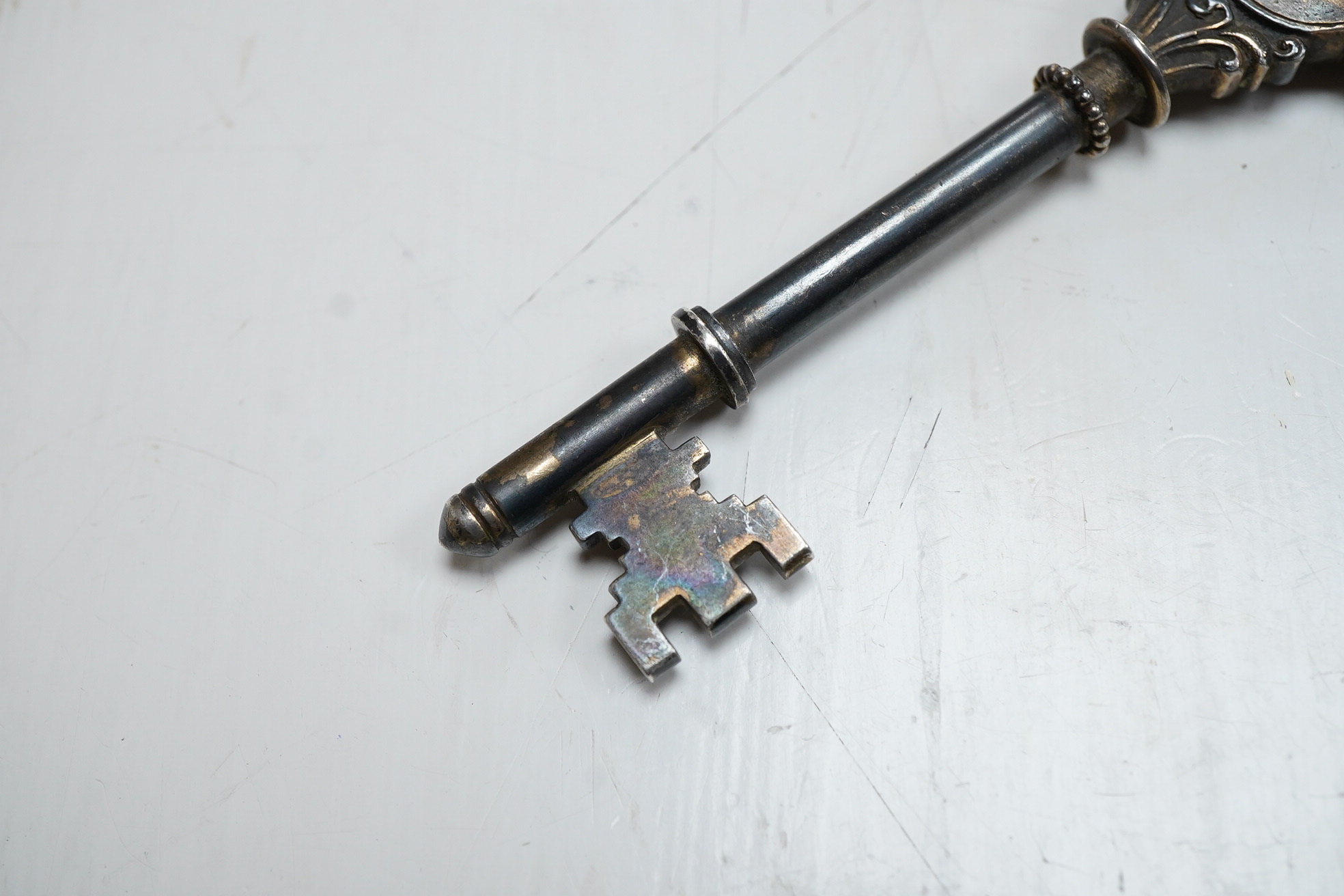 A George V silver presentation? key, engraved with the crest depicting a seated Bishop with mitre above, William James Dingley, Birmingham, 1927, 10.2cm.